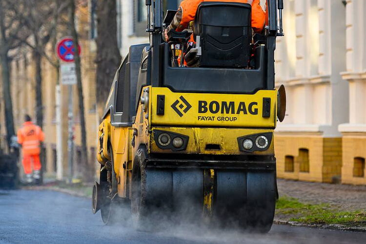 Professionelle Industriefotografie in Leipzig: Aufsteigender Dampf bei 160 Grad heißem Asphalt während der morgendlichen Straßenbauarbeiten.