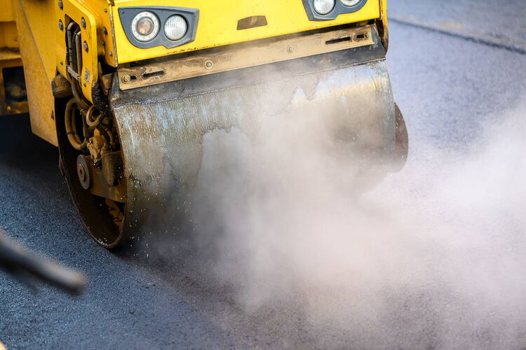 Detailaufnahme der Textur von frisch eingebautem, dampfendem Asphalt auf einer Baustelle in der Region Leipzig.