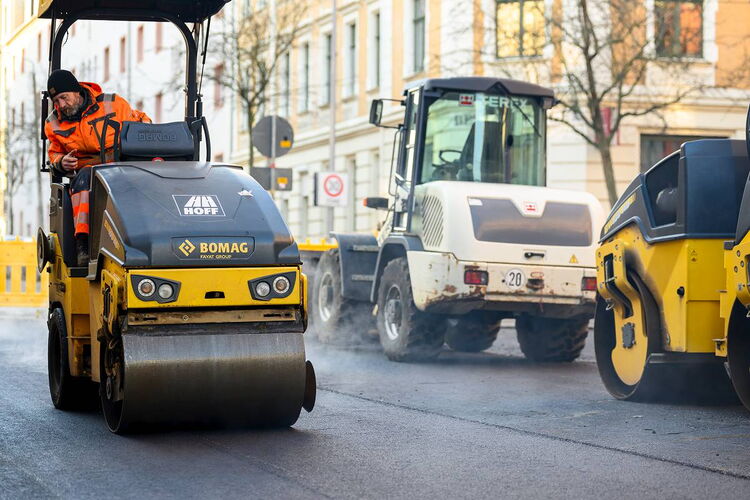 Industriefotograf Leipzig: Dynamische Aufnahme von Baumaschinen und Teamarbeit beim großflächigen Asphalteinbau.