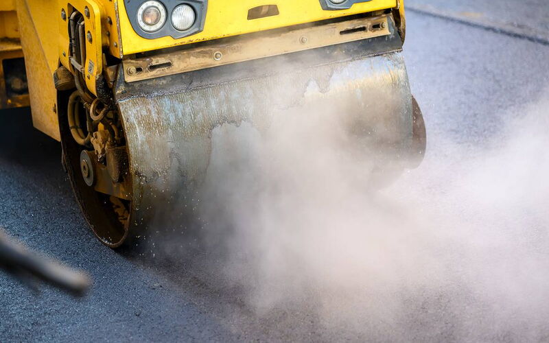 Detailaufnahme der Textur von frisch eingebautem, dampfendem Asphalt auf einer Baustelle in der Region Leipzig.